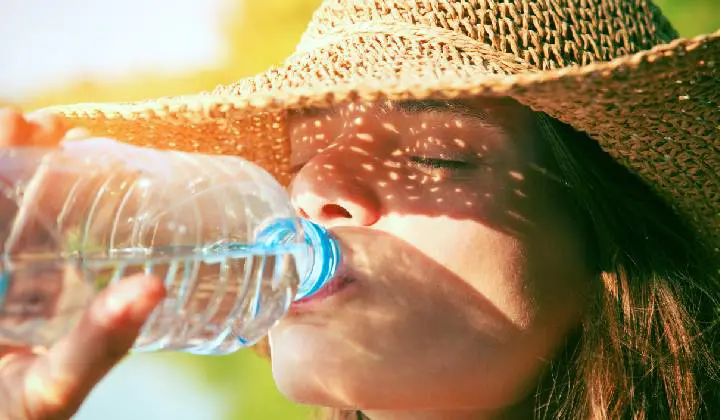 Woman drinking water to rehydrate herself
