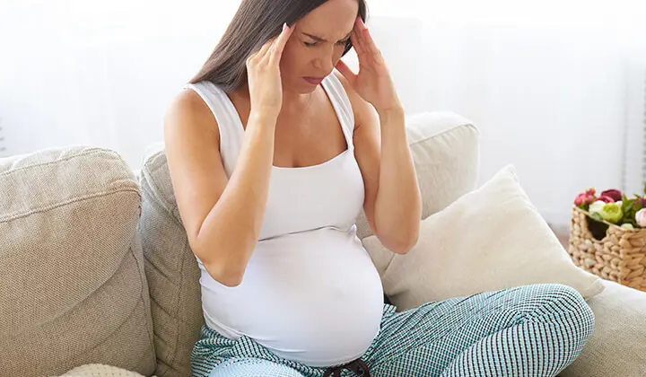 Schwangere Frau mit Kopfschmerzen 